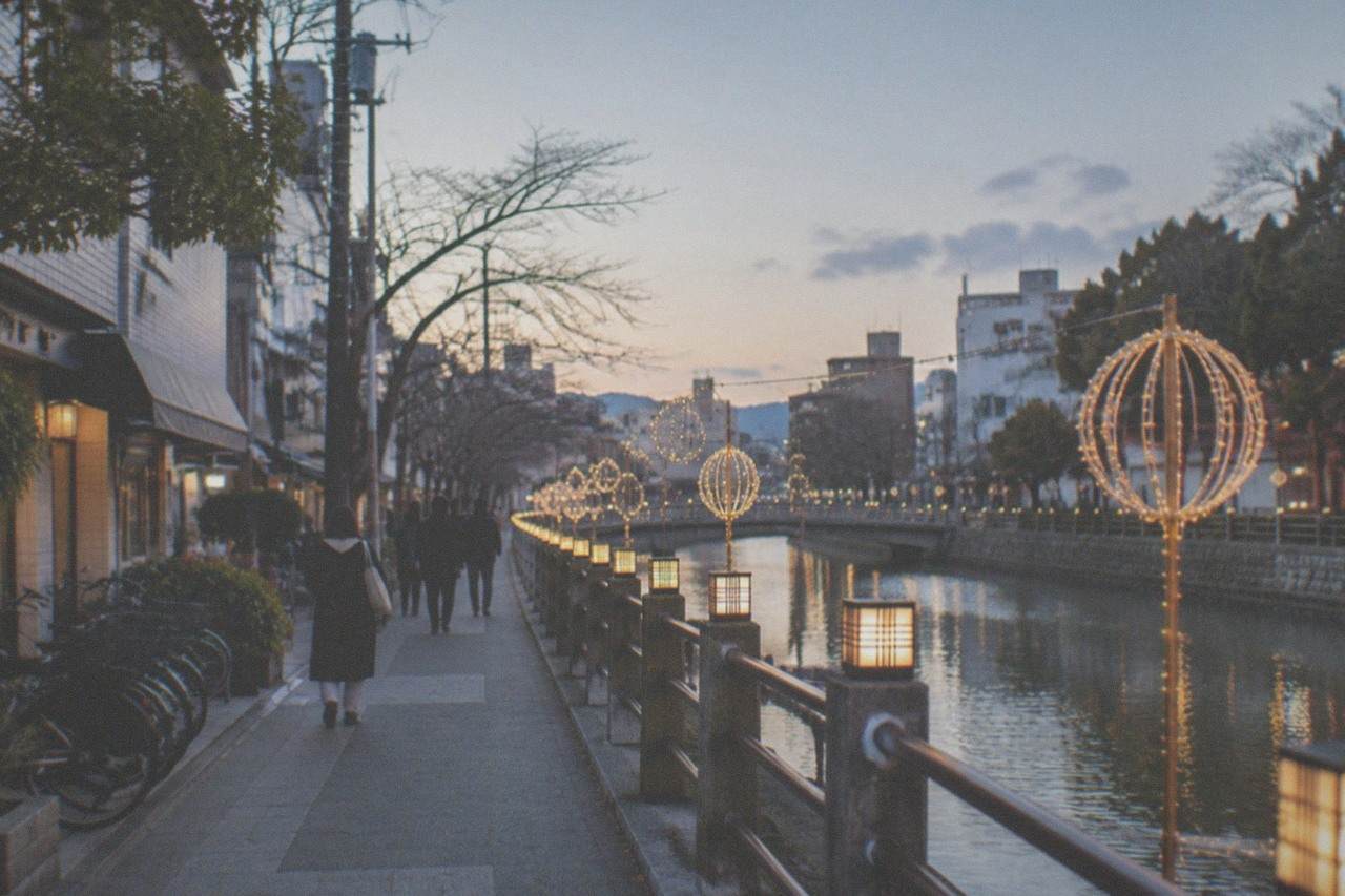 Illuminated winter decorations along a canal in Fukuoka at dusk