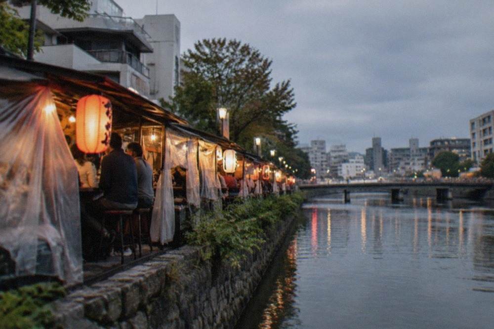Canal-side food stalls glowing along the Naka River in Fukuoka at dusk