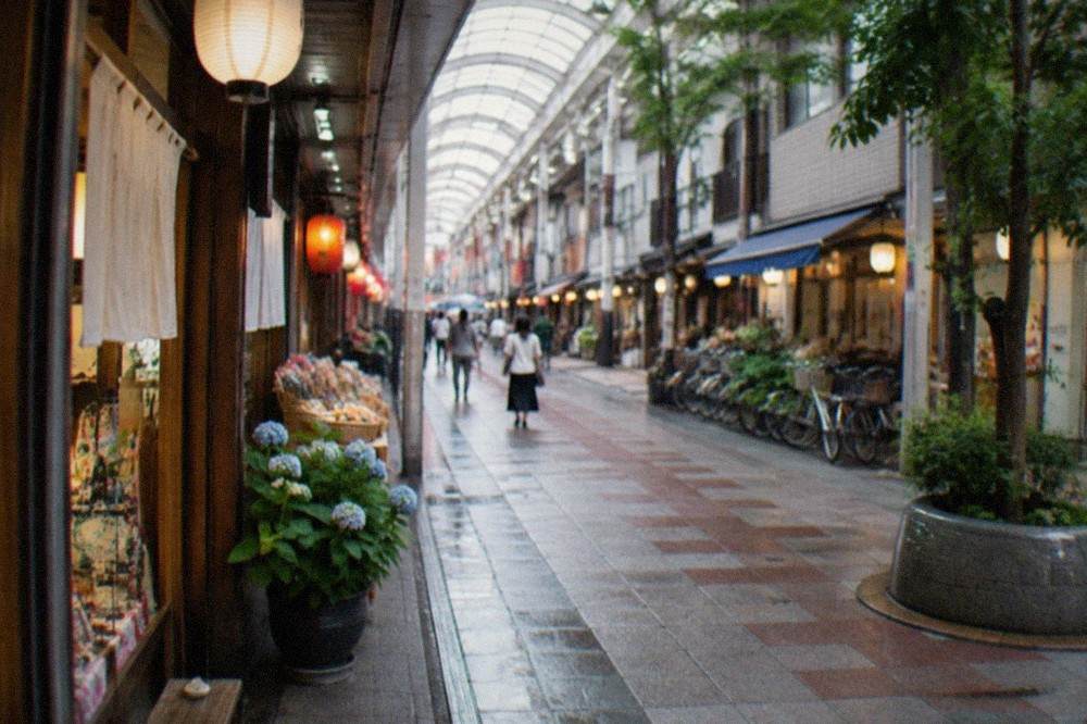 A covered shopping arcade in Fukuoka with small gift shops and lanterns lit for the evening