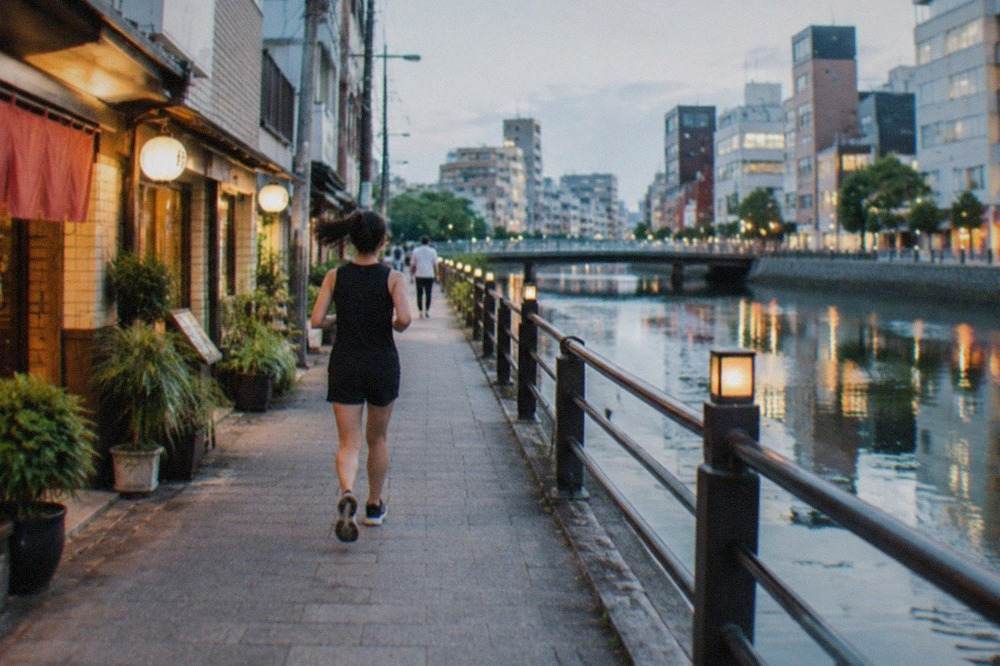 Canal running between illuminated buildings in the Hakata ward of Fukuoka at dusk