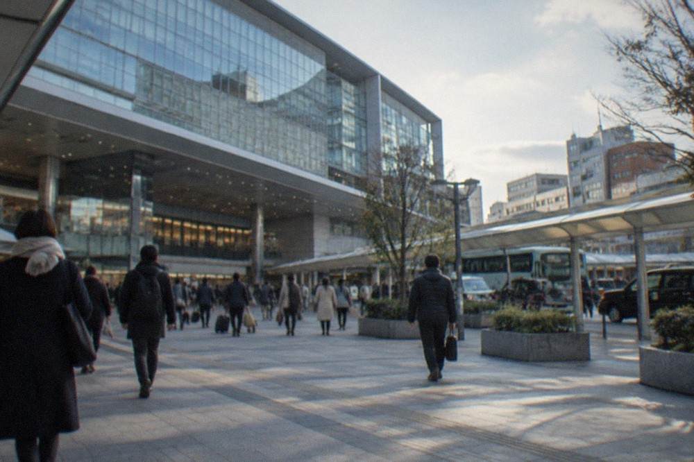 A wide view of Hakata Station concourse with travellers walking beneath departures signage