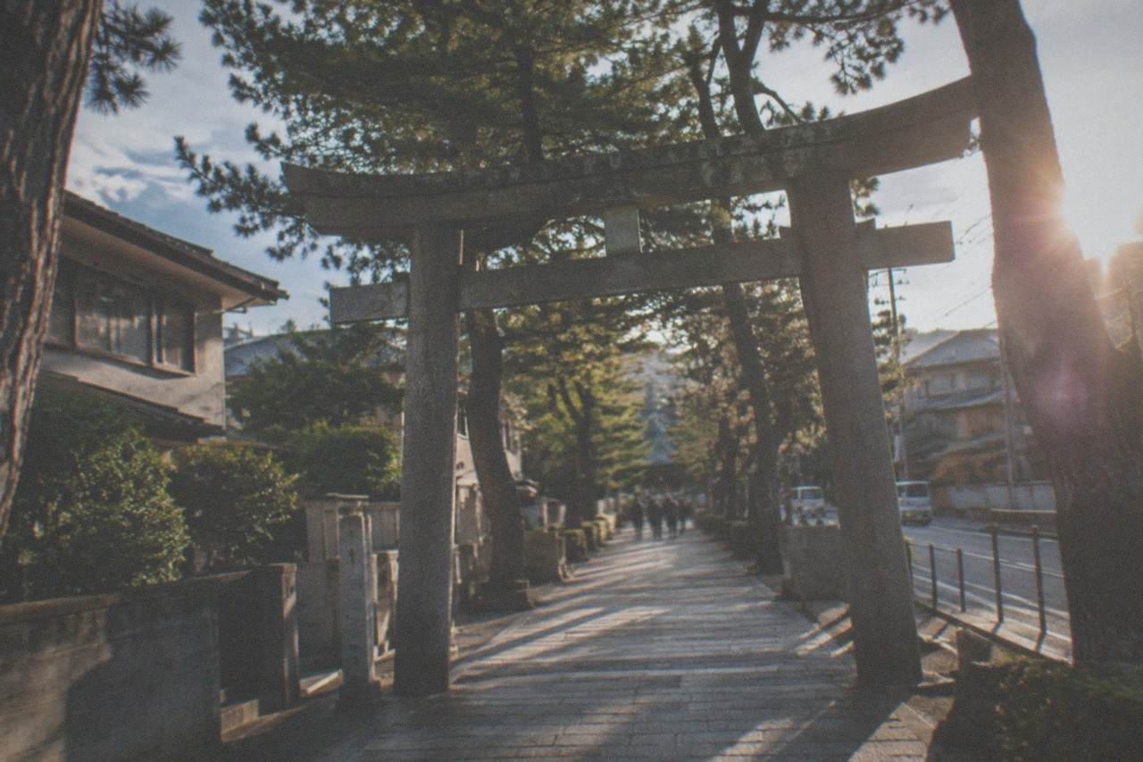 The stone approach and torii gate of a shrine in eastern Fukuoka under a clear sky