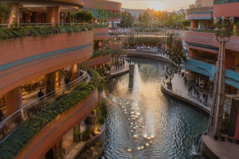 A modern shopping complex built around a curved canal running through its middle