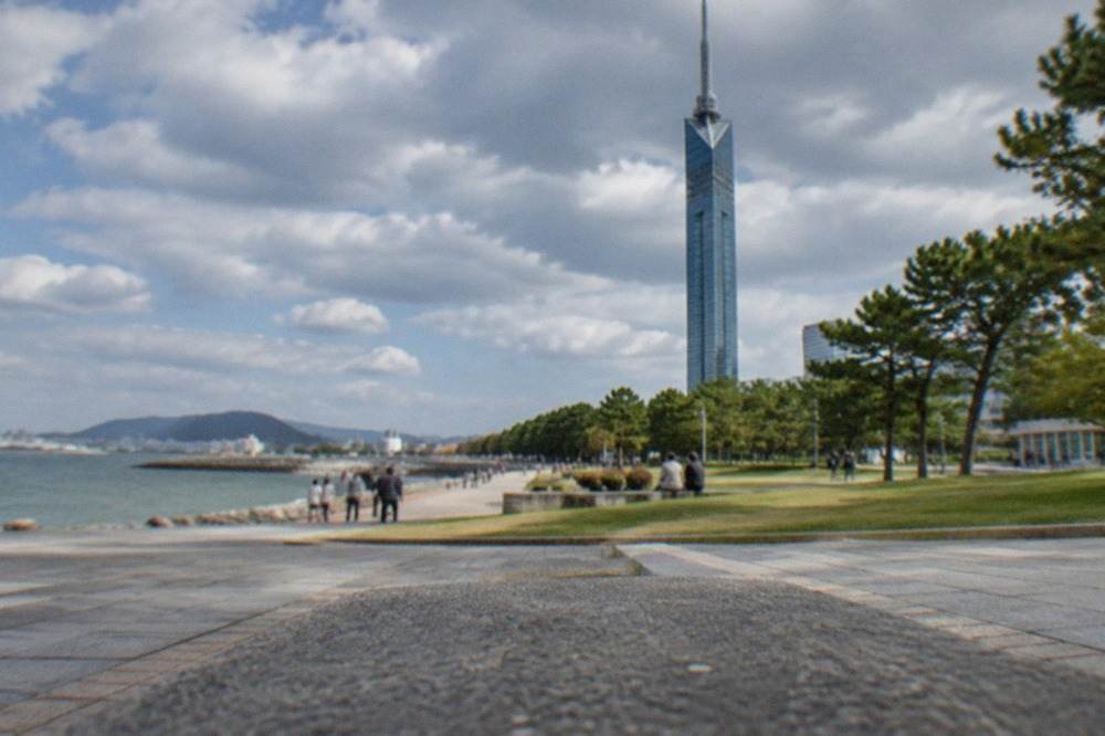 The silver lattice cylinder of Fukuoka Tower standing over the Momochi waterfront
