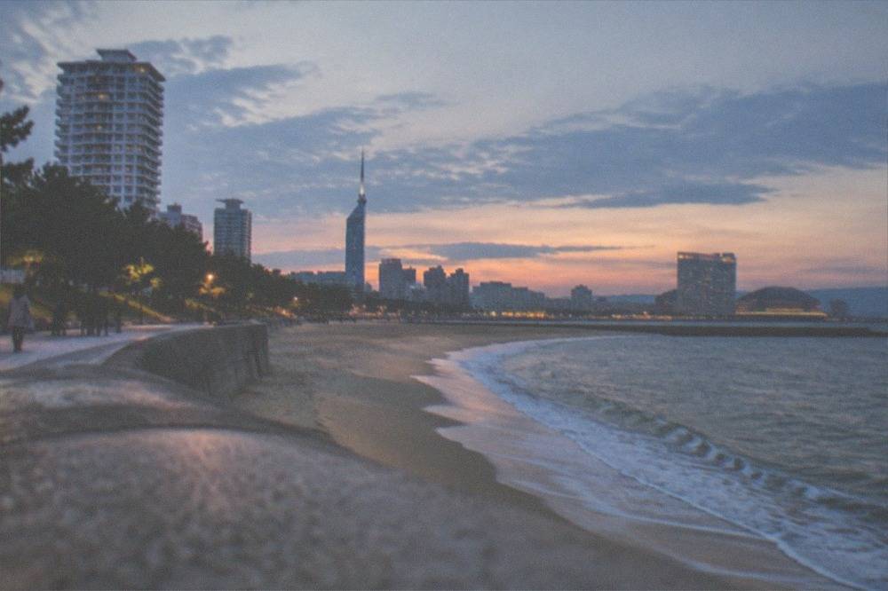 The Momochi beach and promenade at sunset with the city skyline behind