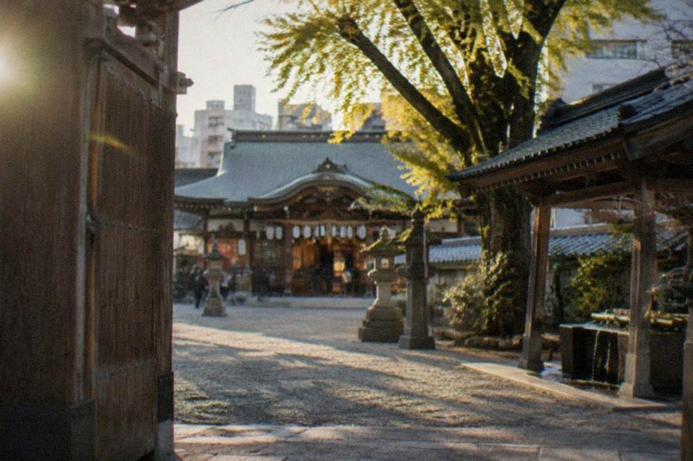 Wooden main hall of Kushida Shrine with lanterns and offerings