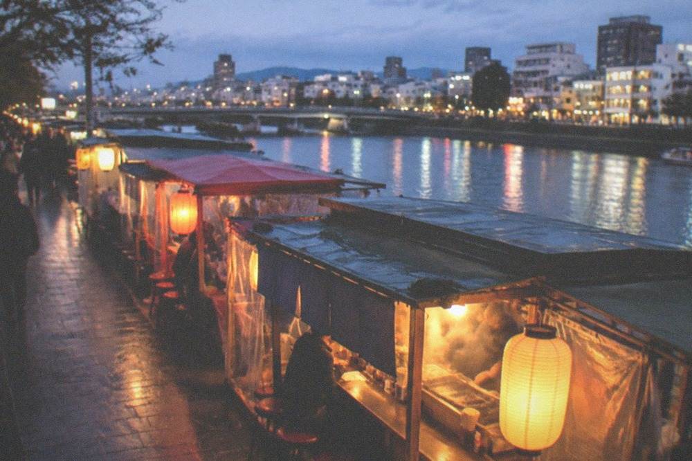 Yatai food stalls lit up along the Naka River at night