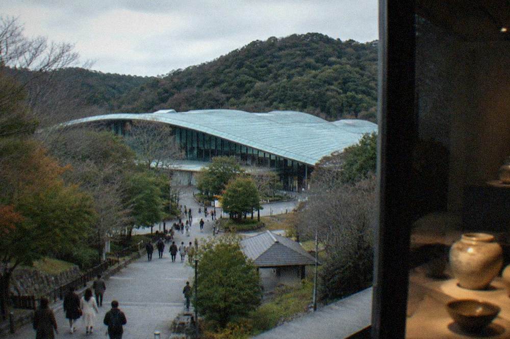 Display cases of ancient ceramics lit softly in a dark exhibition hall