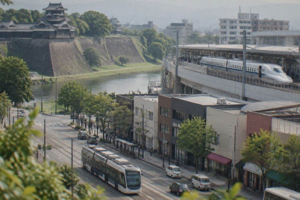 A white Shinkansen train waiting at a station platform with passengers boarding