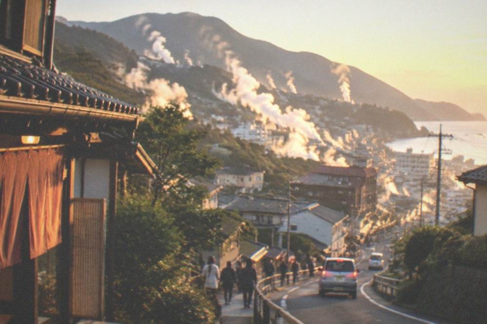 Steam venting from a volcanic hillside above a rural valley road