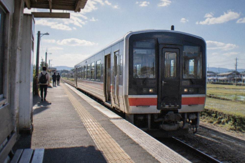 A limited express train standing at a regional station platform in Kyushu