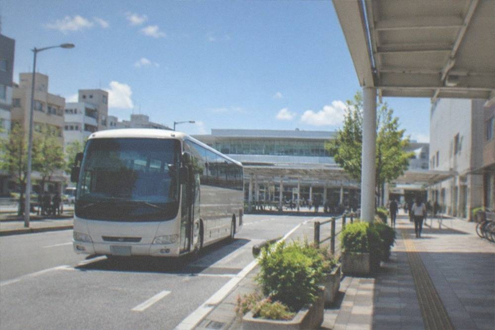 A bus bay outside an airport terminal with a coach at the kerb