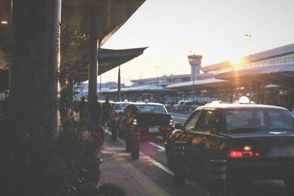 A taxi rank outside an airport terminal at dusk