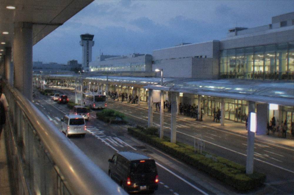 The Fukuoka Airport terminal exterior seen from a covered pedestrian bridge