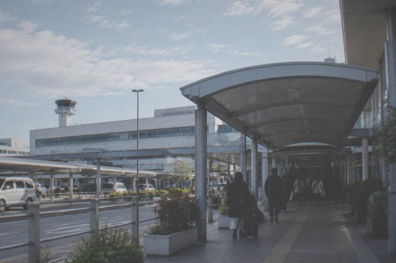 Fukuoka Airport terminal exterior with a covered walkway leading to a subway station entrance