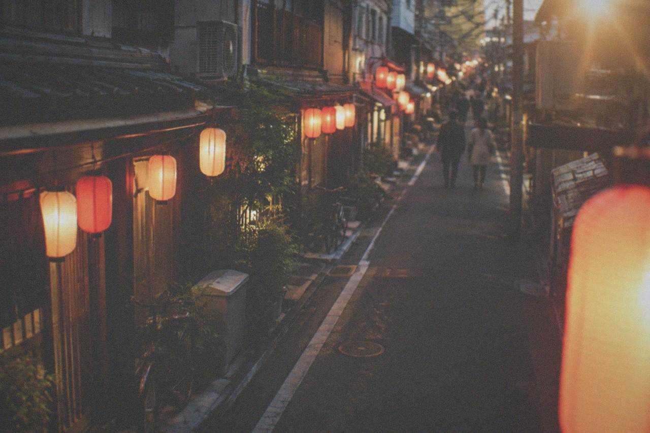 Izakaya lanterns glowing along a narrow street in the Daimyo district at night
