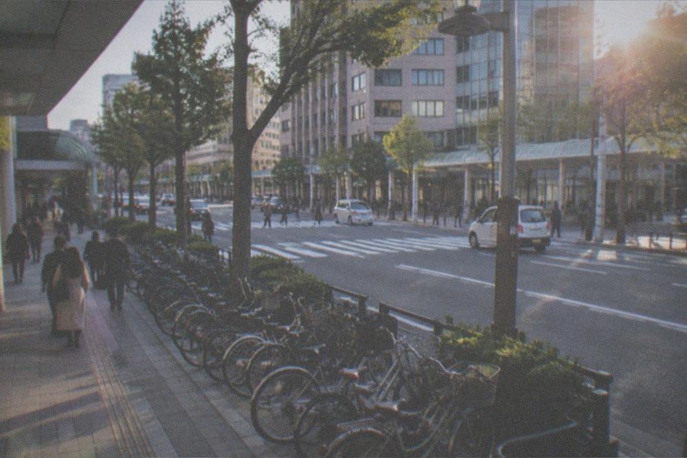 Bicycles parked in neat rows along a sidewalk in the Tenjin district of Fukuoka