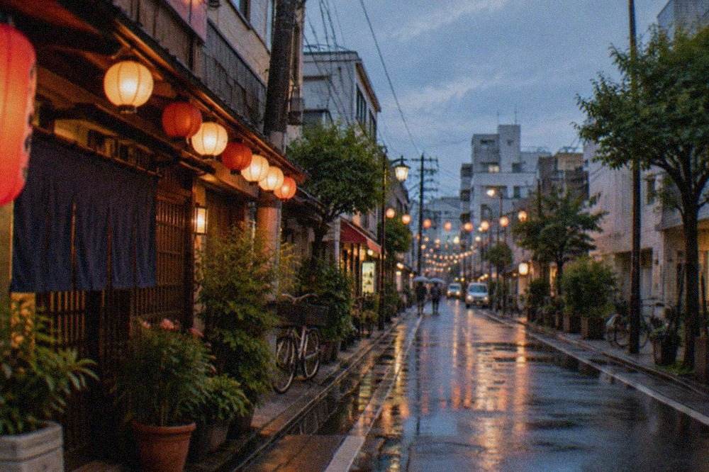A quiet Fukuoka restaurant street at dusk with lanterns glowing above closed storefronts