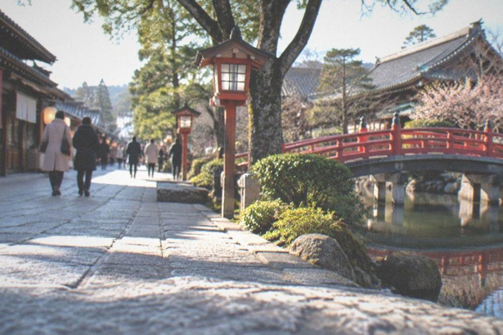Approach street to Dazaifu Tenmangu in winter with lanterns and traditional shopfronts under a clear sky