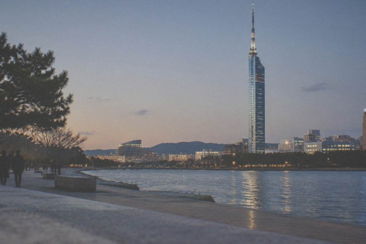 Fukuoka city skyline at dusk in winter with Fukuoka Tower lit up against a clear evening sky