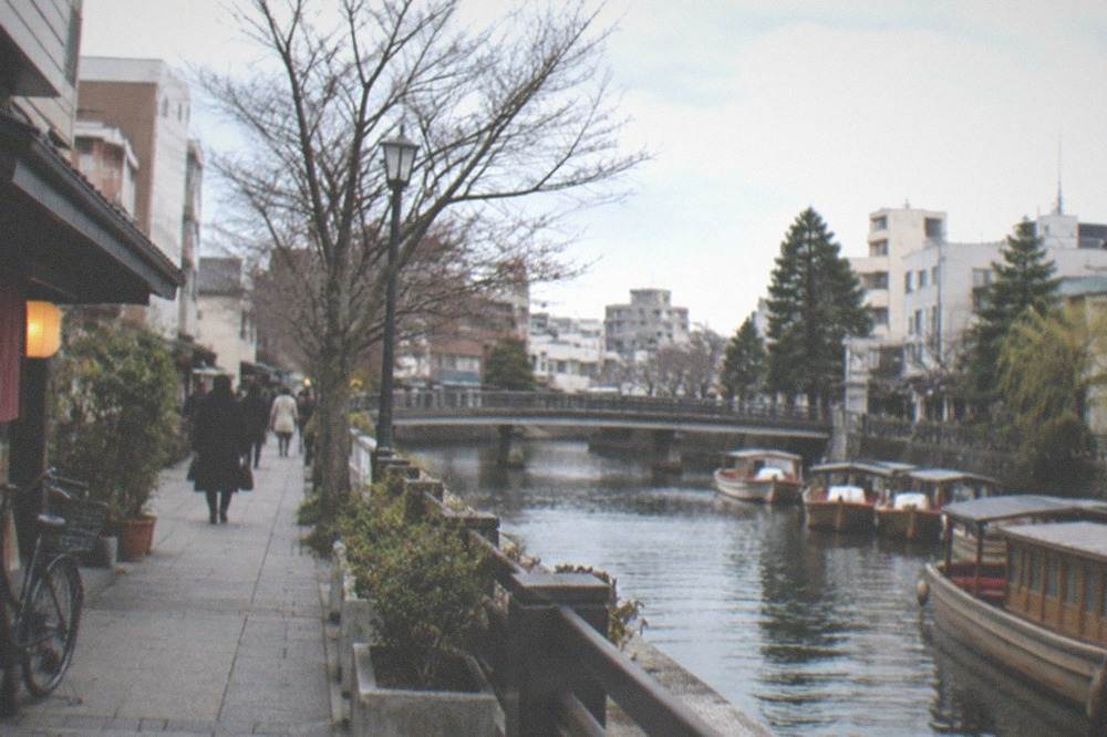 Traditional canal boats moored along a waterway in a small Japanese town