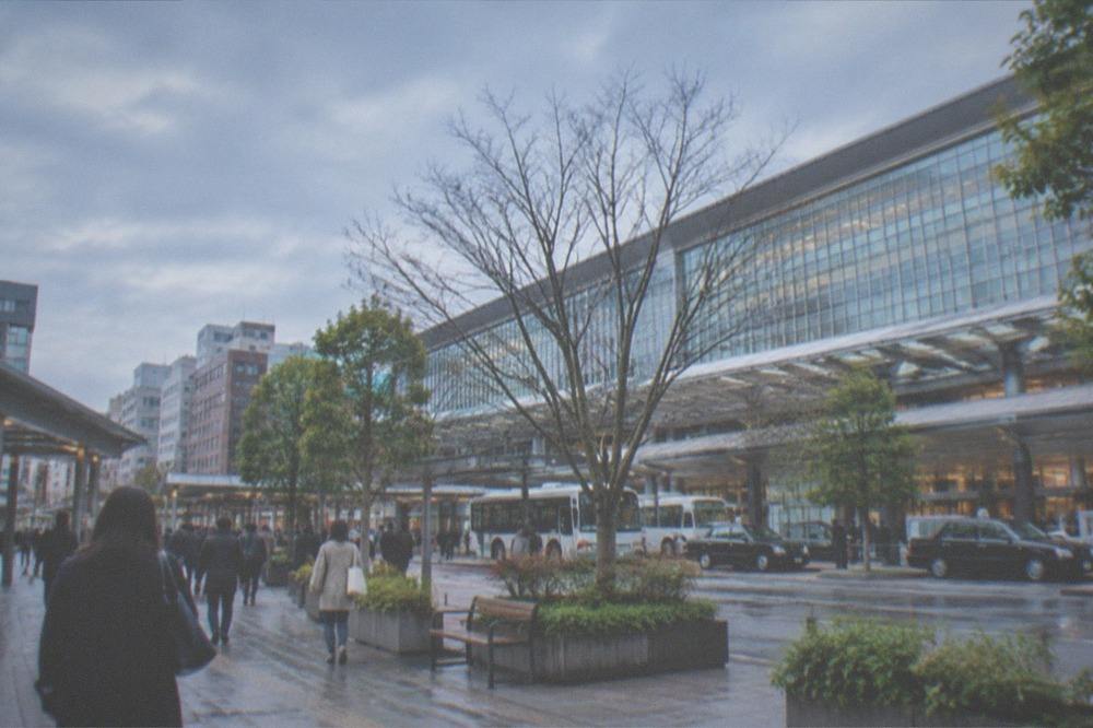 Modern subway station concourse with signs and turnstiles in Fukuoka