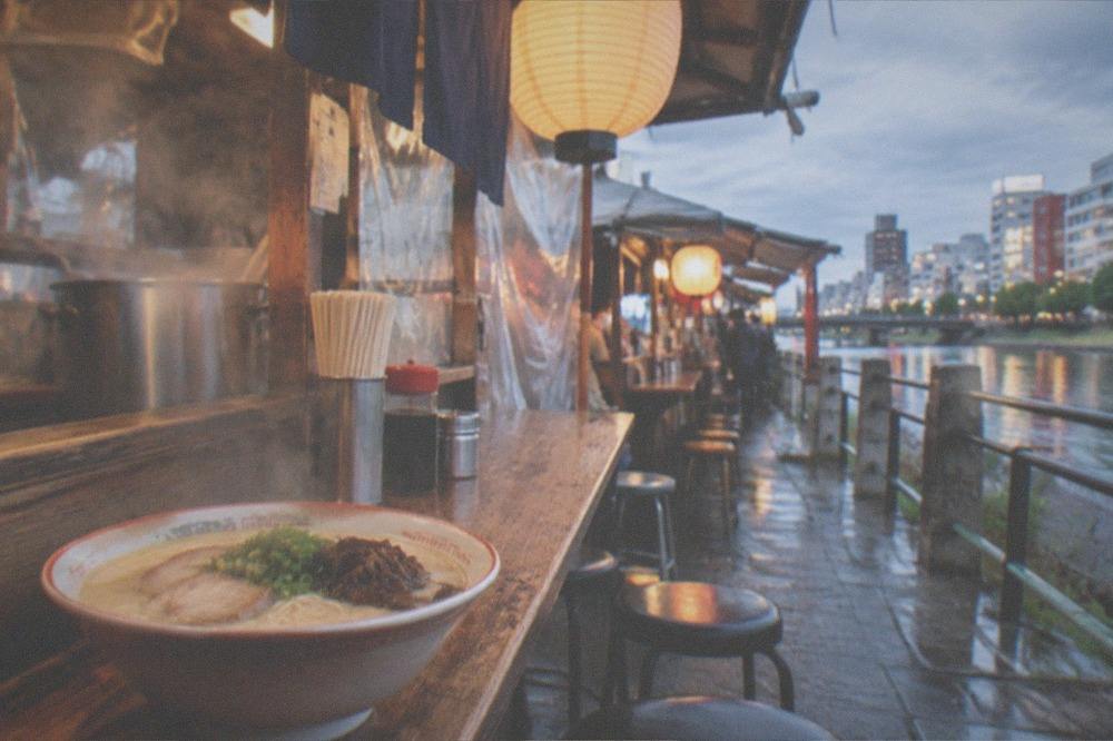 Freshly served bowl of tonkotsu ramen on a wooden yatai counter