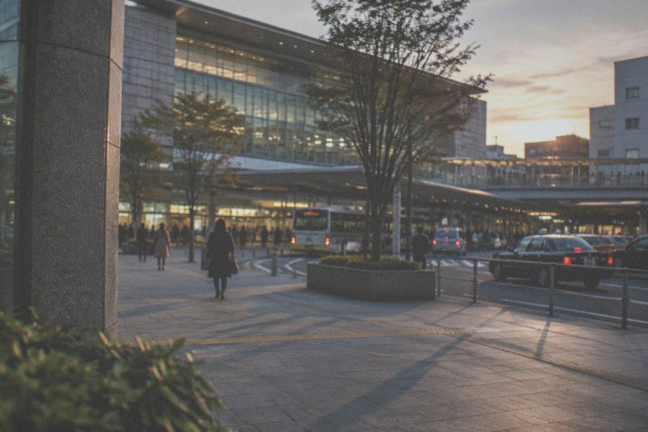 Hakata Station exterior at dusk with illuminated signage and city buildings