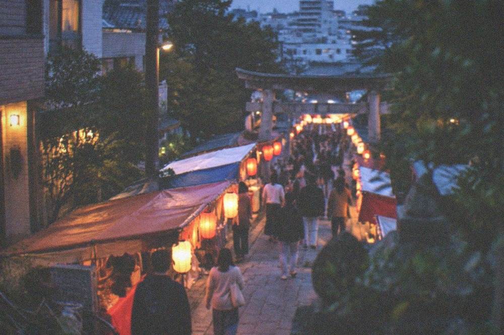 A shrine approach lined with rows of festival stalls under lantern light