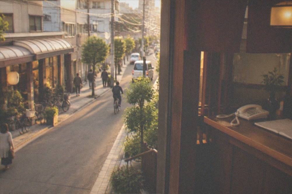 A reception desk with a telephone and reservation book in a small warmly lit restaurant entrance