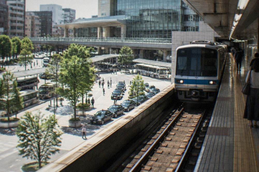 A subway platform with a train arriving beside a tiled station wall