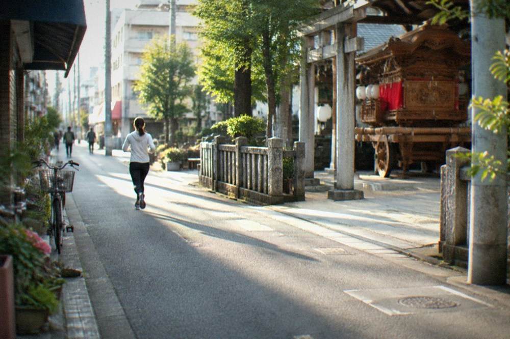 A wooden festival float standing inside a shrine grounds