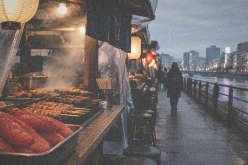 Close view of spicy mentaiko pollock roe and small grilled skewers on a market counter