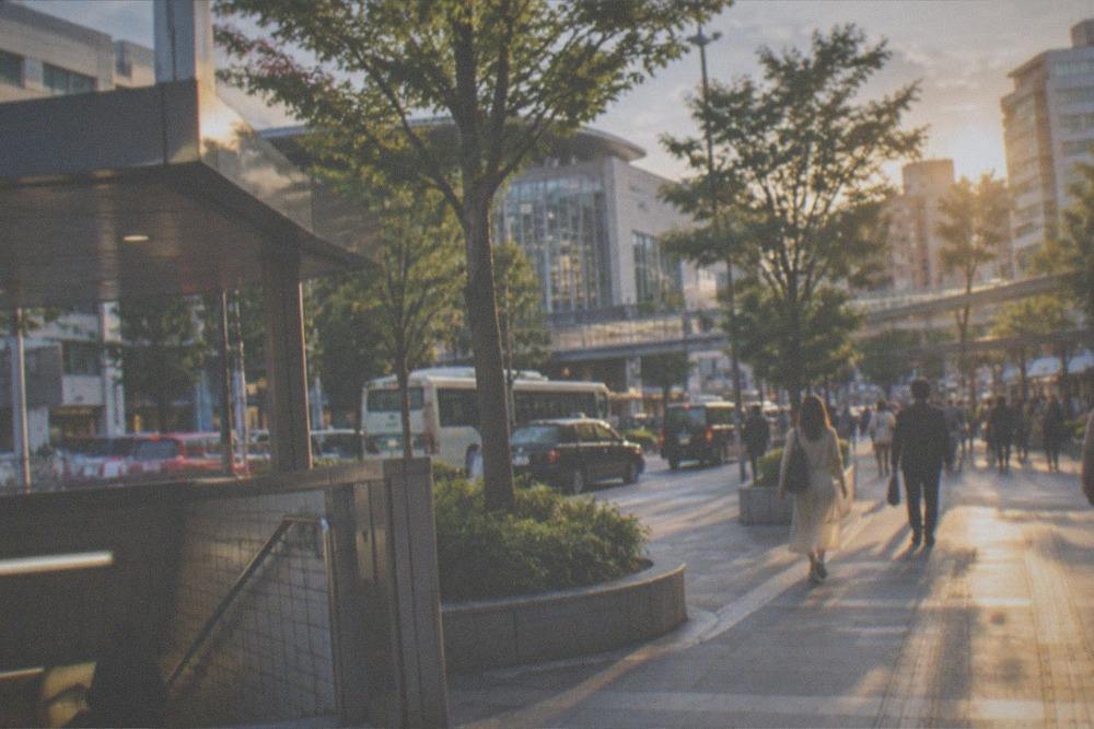 A subway station exit opening onto a tree-lined street in central Fukuoka