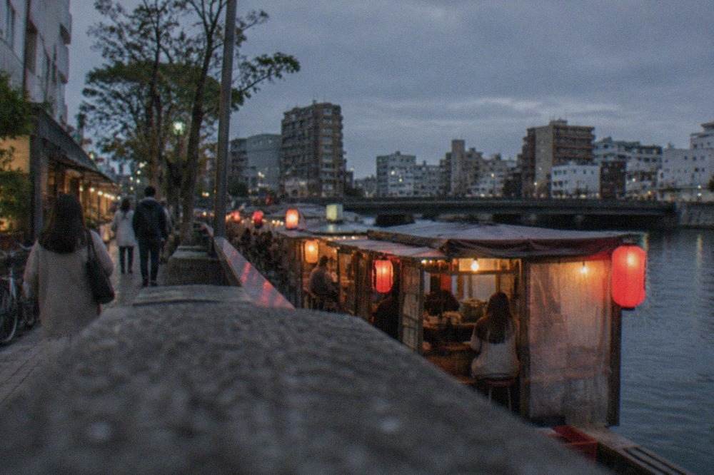 Lantern-lit evening food stalls lined up along the Naka river in Fukuoka