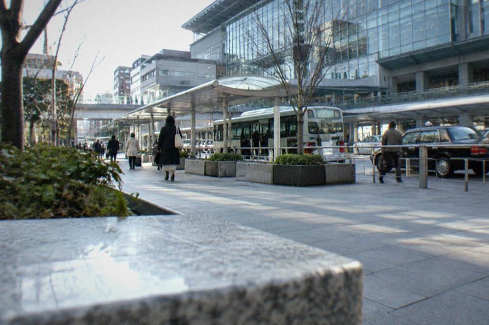 A clean modern subway platform in a Japanese station with a train stopped and doors open