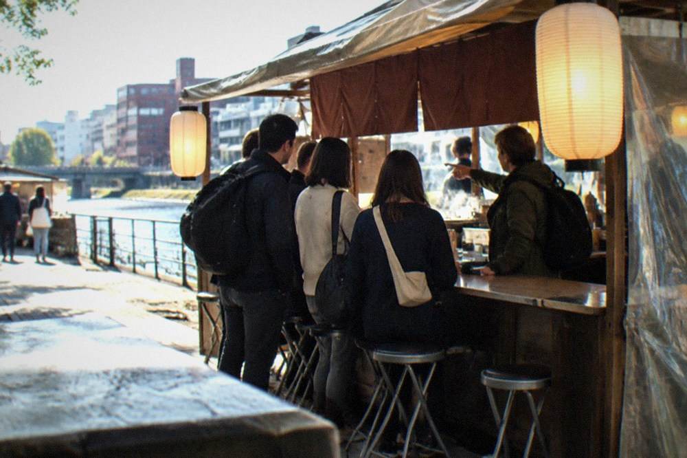 Guided group standing at a lantern-lit food stall counter while a guide points at menu items