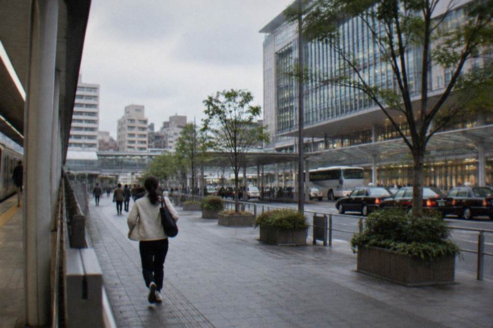 A clean subway platform in Fukuoka with a train arriving and signage overhead