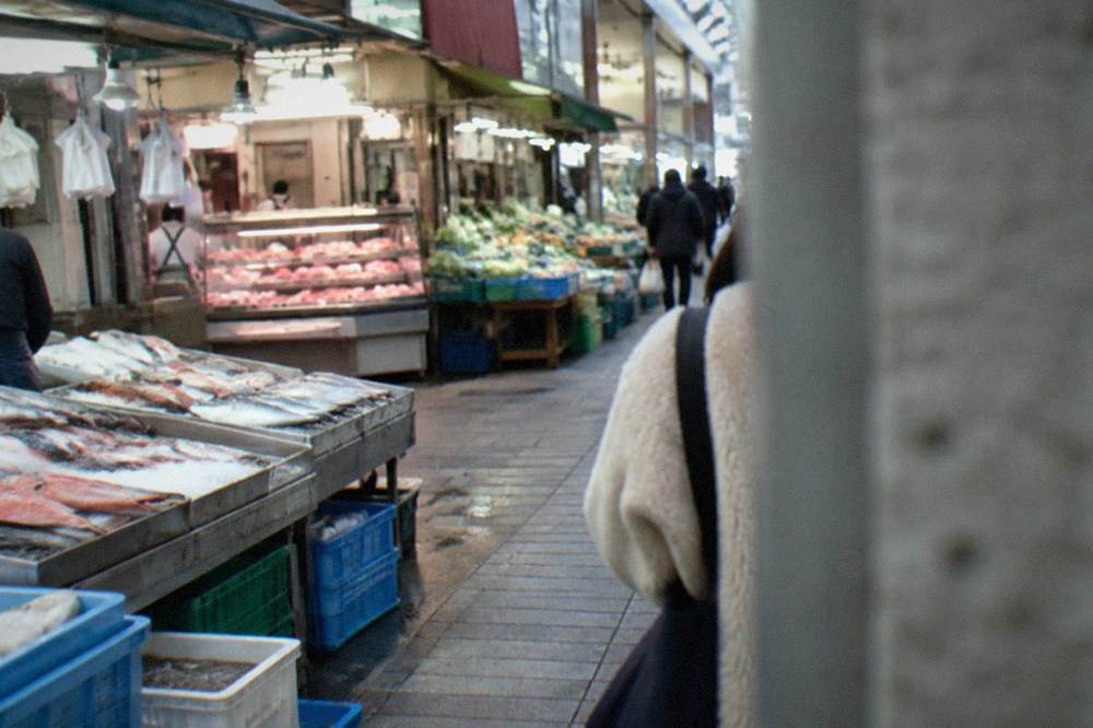 busy basement food hall counters with trays of prepared dishes under bright lights