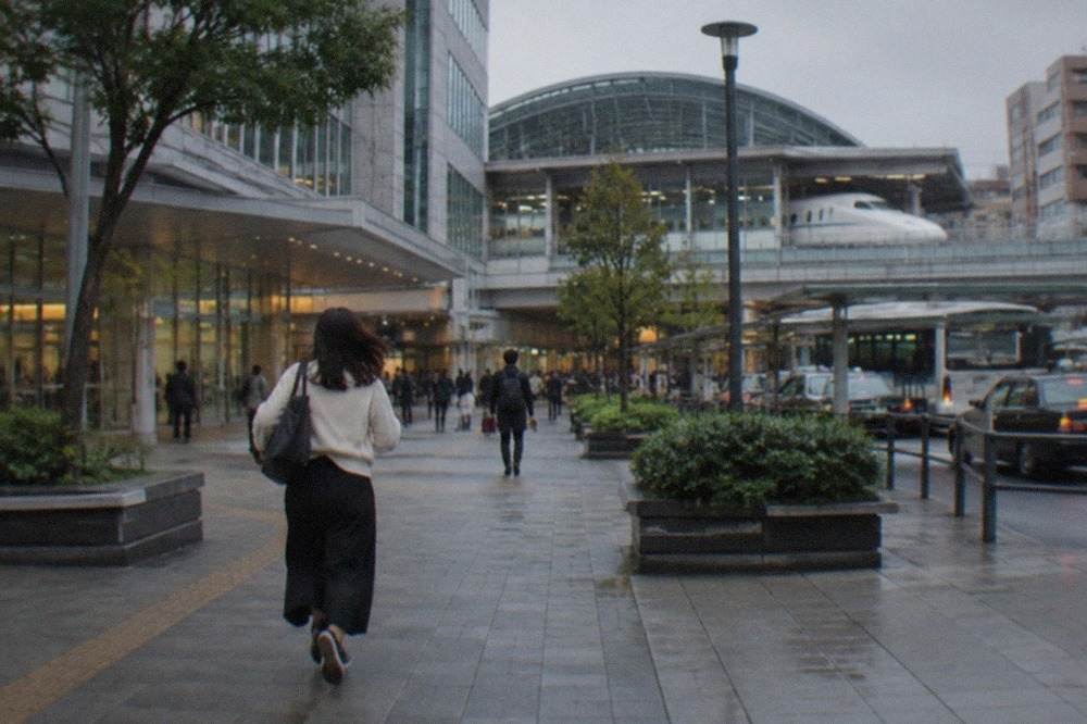 A bullet train platform with a white train nose visible under a curved canopy