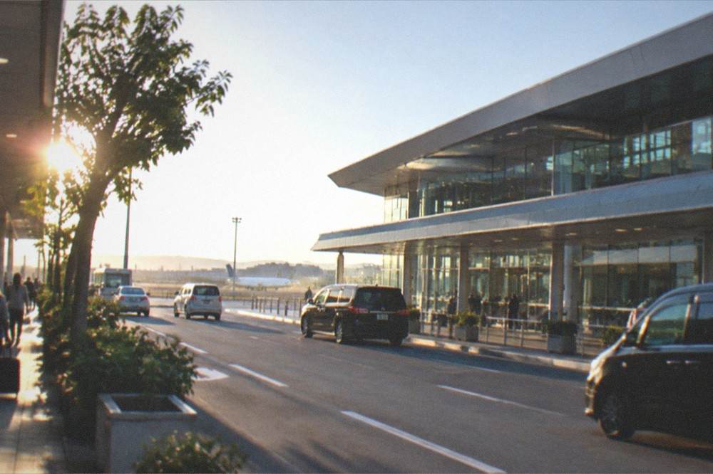 Fukuoka Airport terminal building exterior under a clear sky with the runway beyond