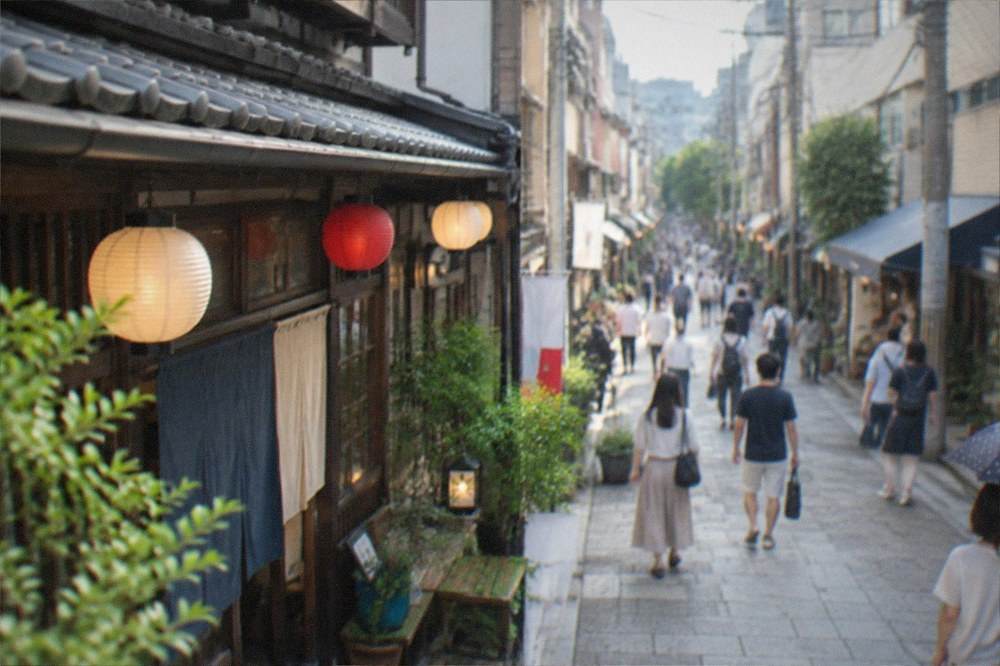 A traditional shopping street with wooden storefronts and hanging lanterns