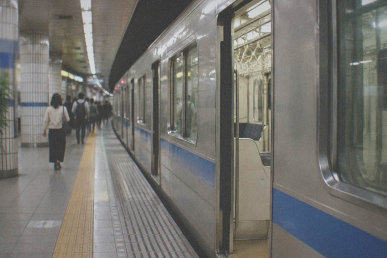 A subway platform at a Fukuoka City subway station with a train waiting at the doors