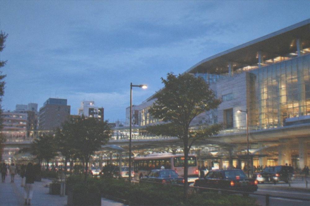 A clean subway station platform with a train waiting at night in a Japanese city